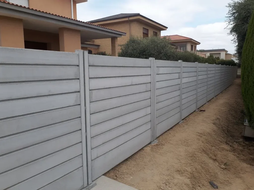 Instalacion cerramiento de hormigon con placas prefabricadas en zona residencial junto a viviendas